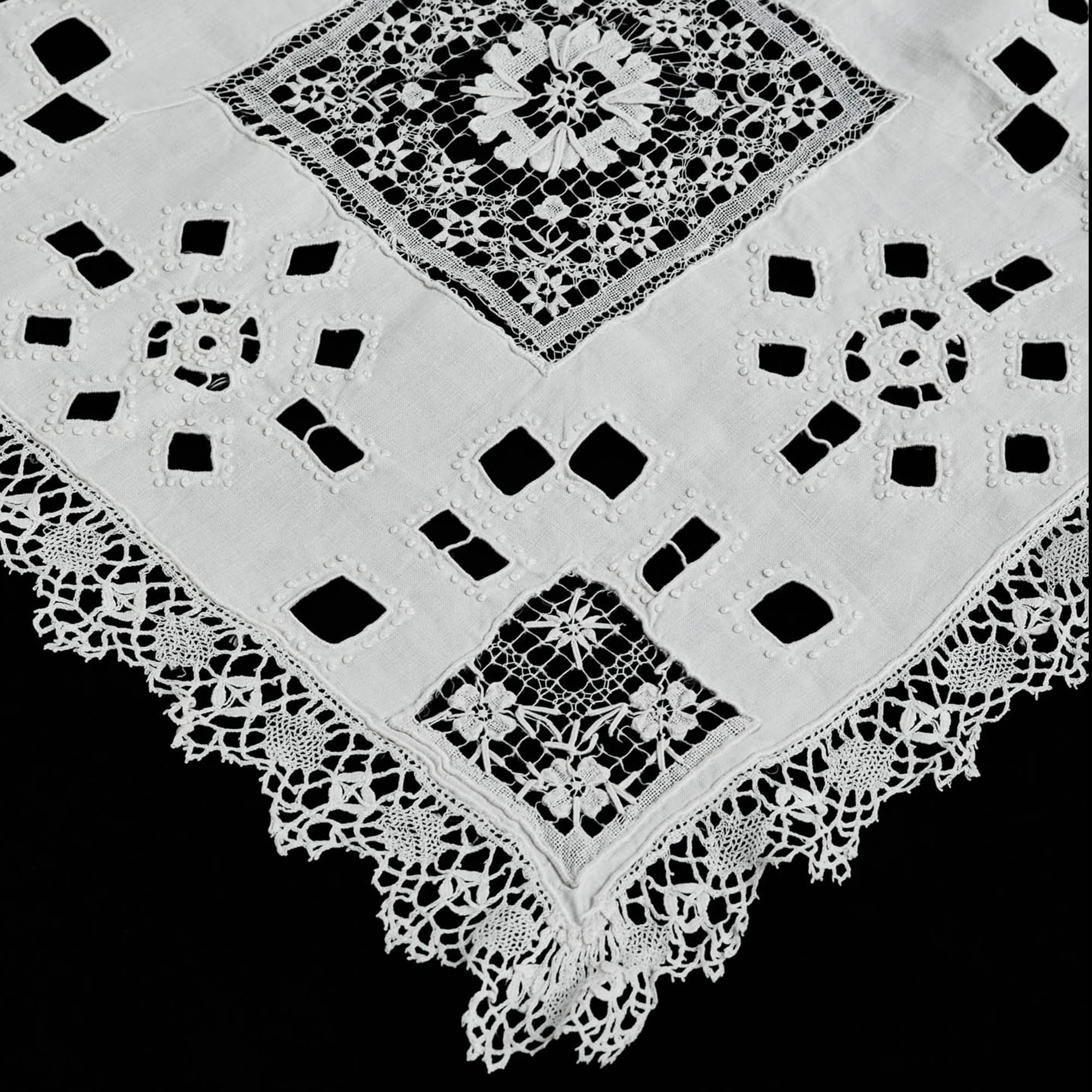 Detail of white linen table runner showing lace and openwork embroidery