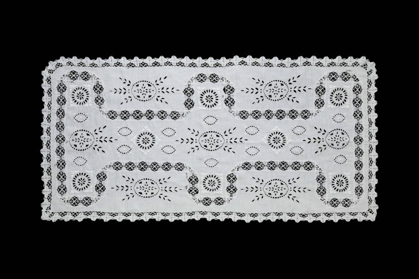 Full view of white linen table runner featuring openwork embroidery and lace border